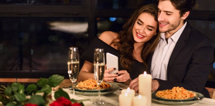 happy-couple-using-smartphone-restaurant-1-2